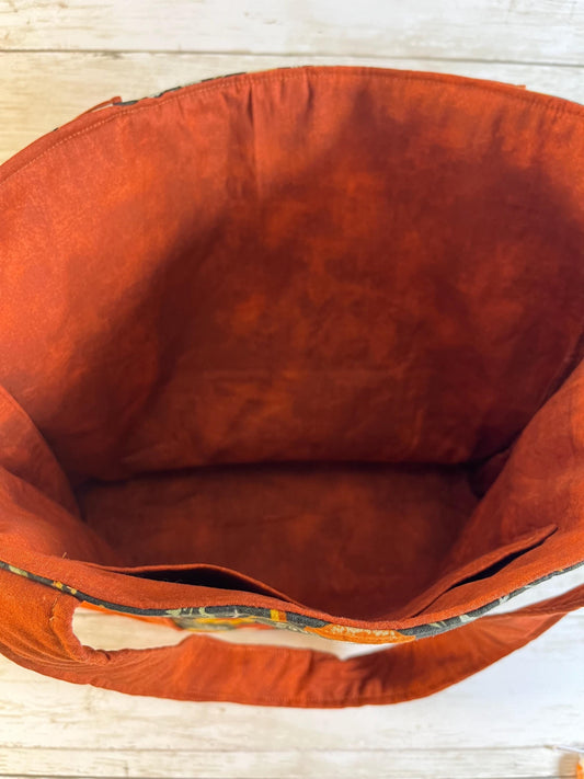 Close-up of an orange fabric bag with a wooden surface background