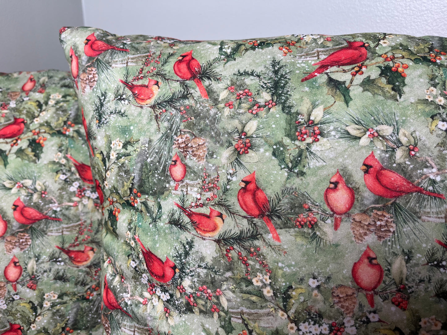Floral and cardinal bird patterned fabric with red cardinals on a green background