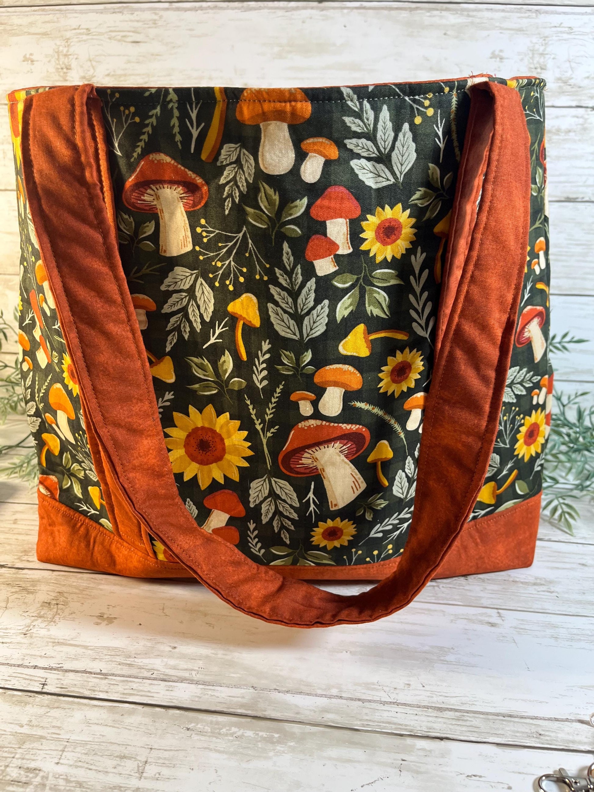 Tote bag with mushroom and floral pattern on a wooden surface
