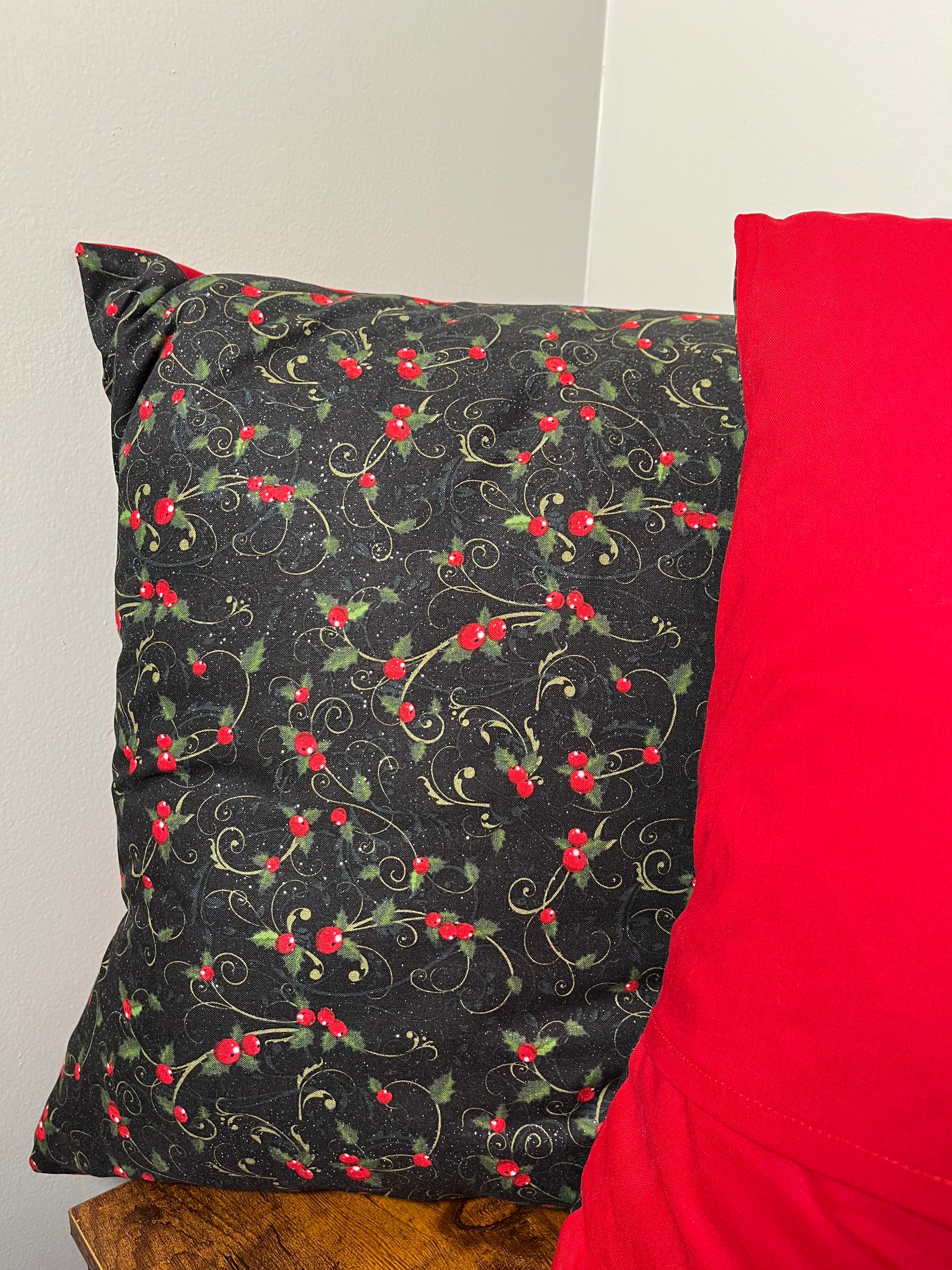 Holly berry throw pillows red fabric on top of a black fabric with red berry pattern